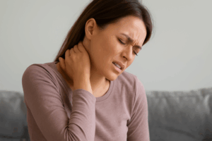 A woman is suffering from whiplash pain after being in a car accident.